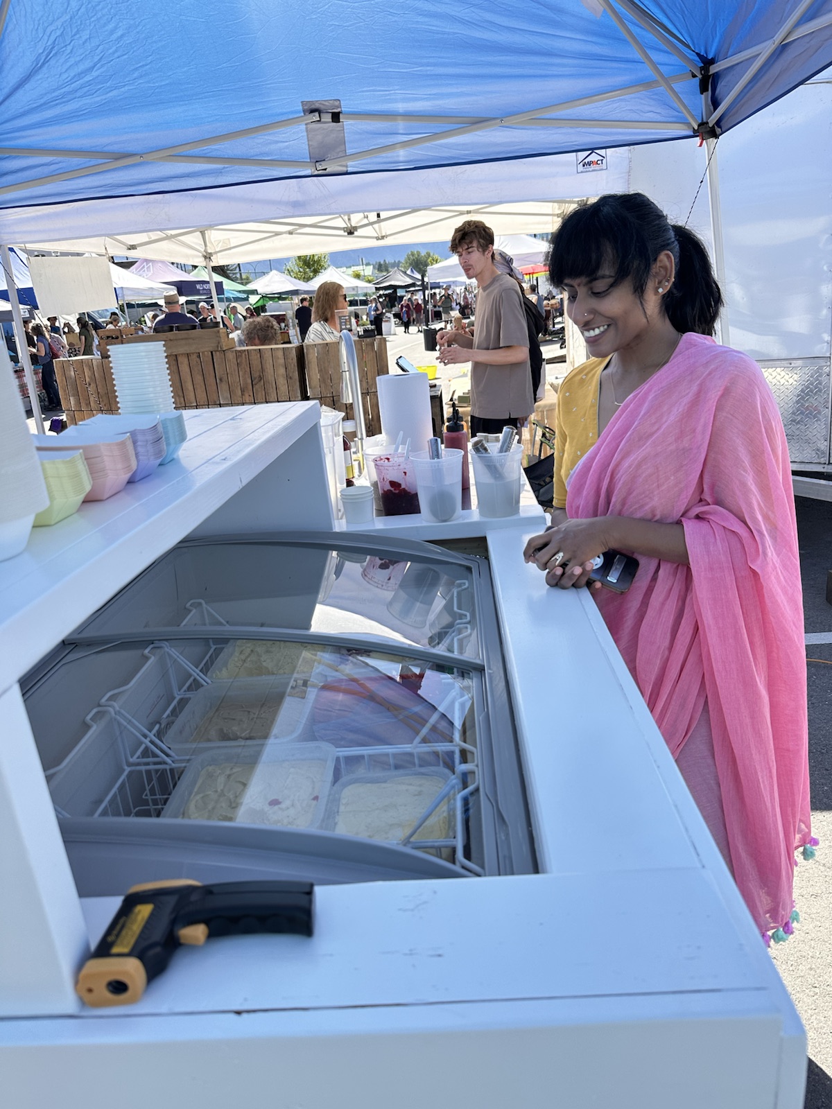 A customer choosing ice cream at the JUNU market cart