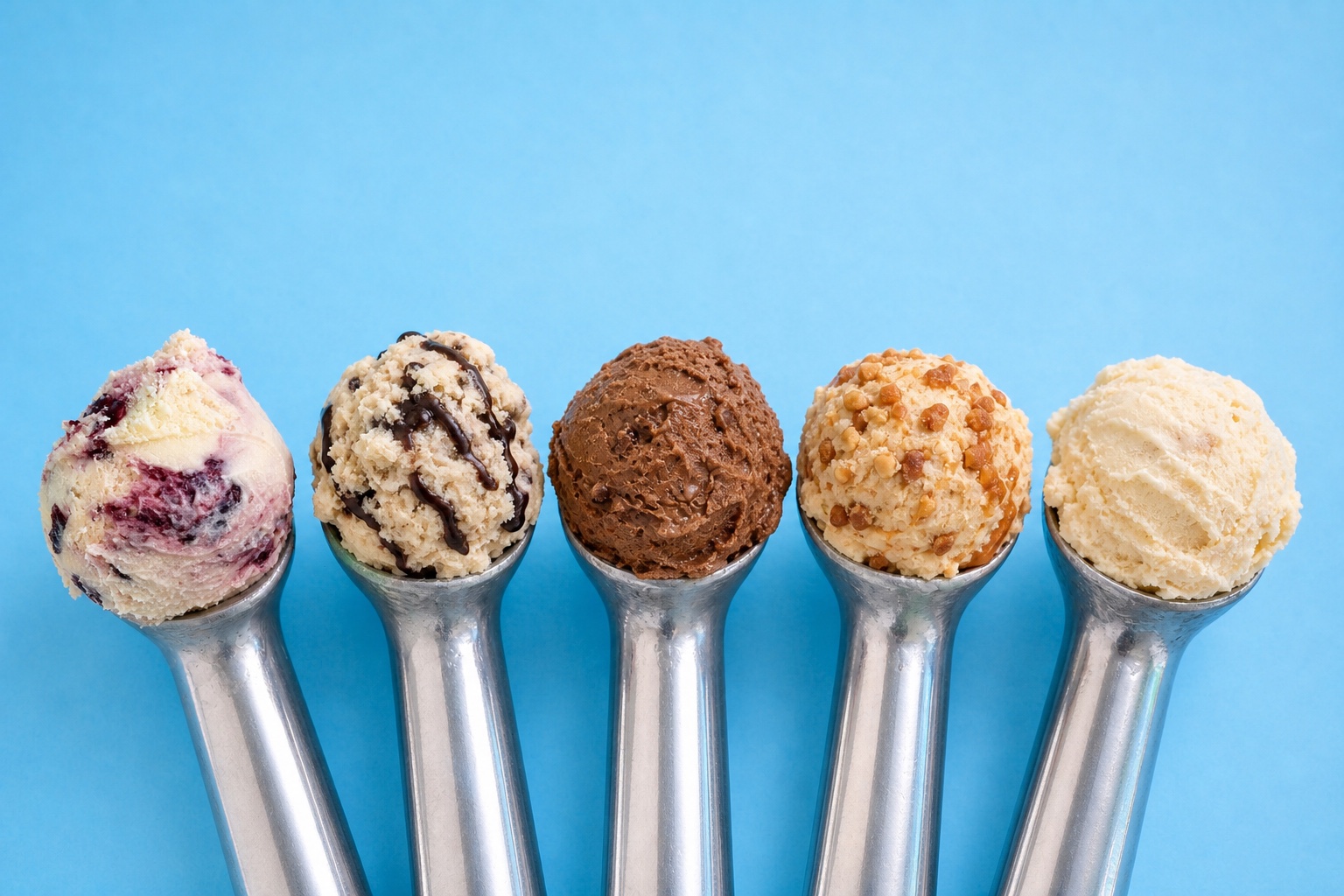 Five JUNU ice cream flavours presented in stainless-steel scoopers